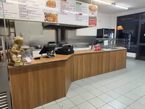 Existing pizza shop counter in dated timber-look laminate.