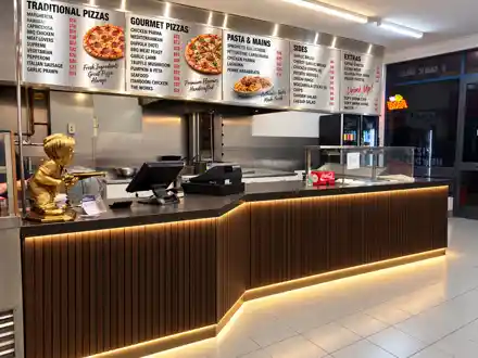 Concept visual of the same counter rebuilt with a fluted timber face, stone top and recessed lighting.